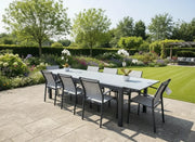 Outdoor patio set with table and chairs in a garden setting