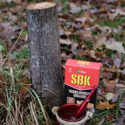 SBK tree care product with a cup and tool on a forest floor background