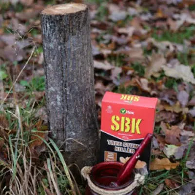 SBK tree care product with a cup and tool on a forest floor background
